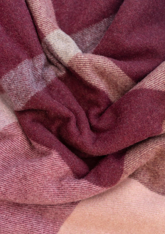 A close-up of TBO's Berry Block check blanket to show the herringbone texture and block checker pattern in orchid, purple, and violet tones