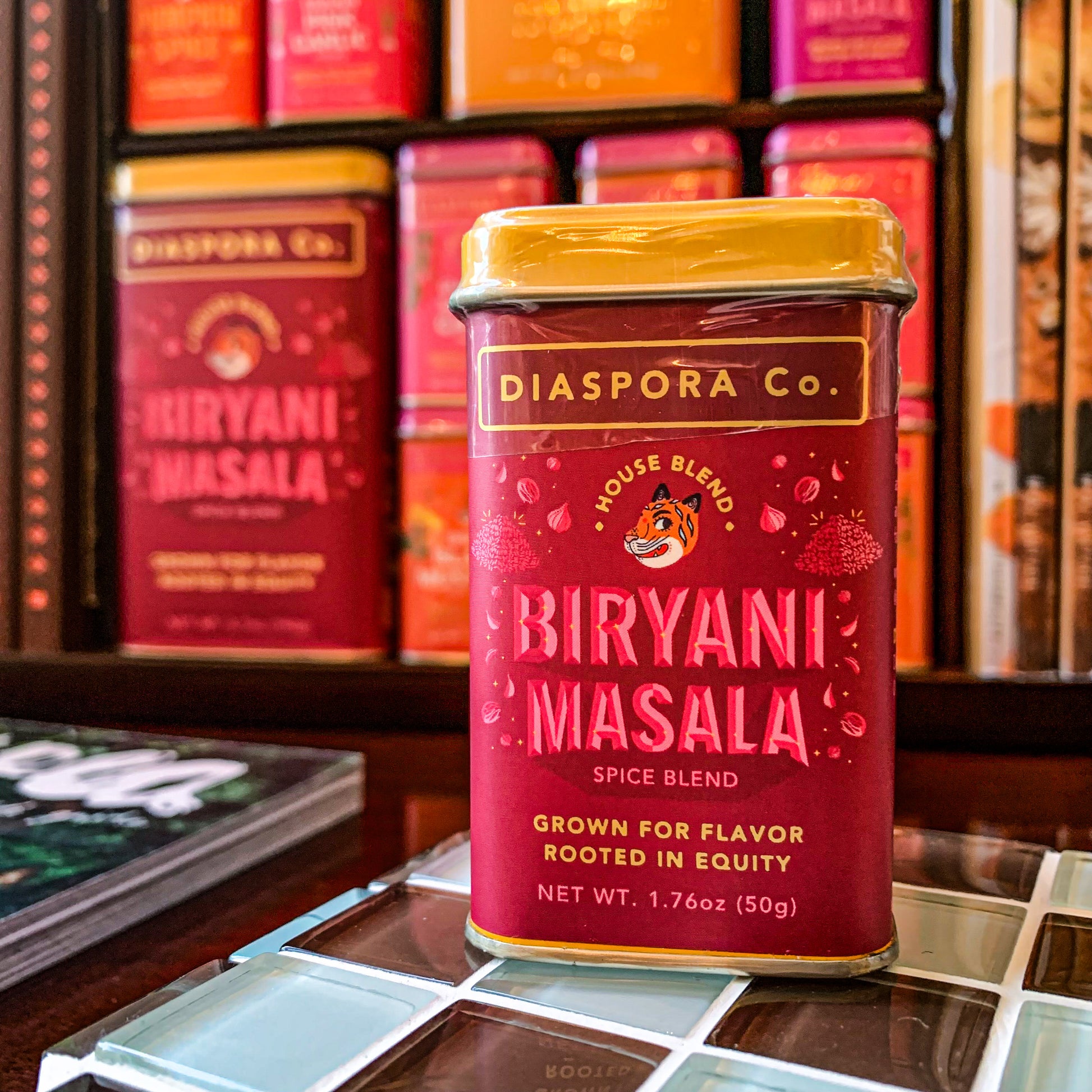 Diaspora co biryani masala home tin spice mix in front of shelf display 