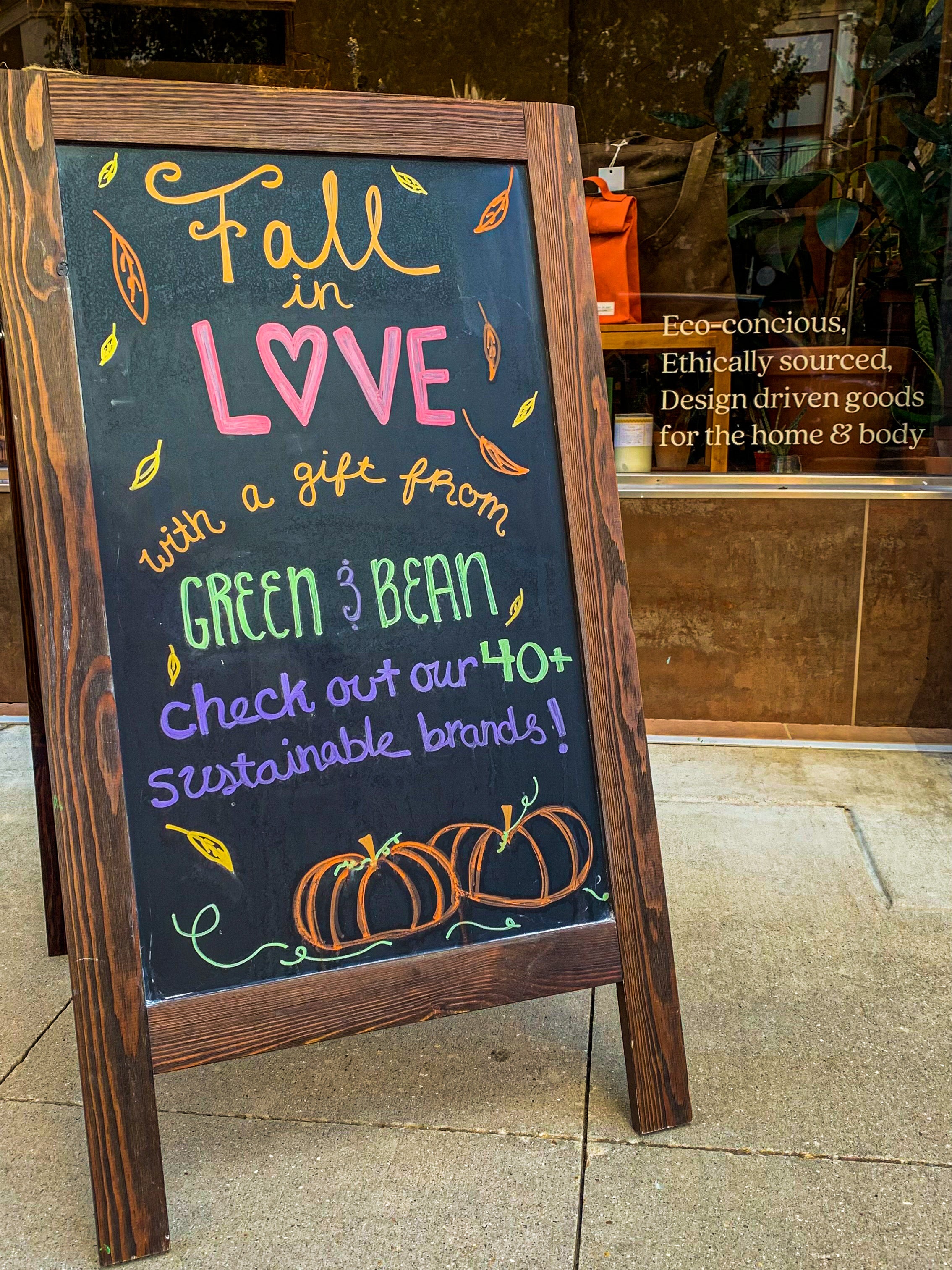 Retail shop sidewalk sign that says "Fall in love with a gift from Green & Bean: check out our 40+ sustainable brands!"