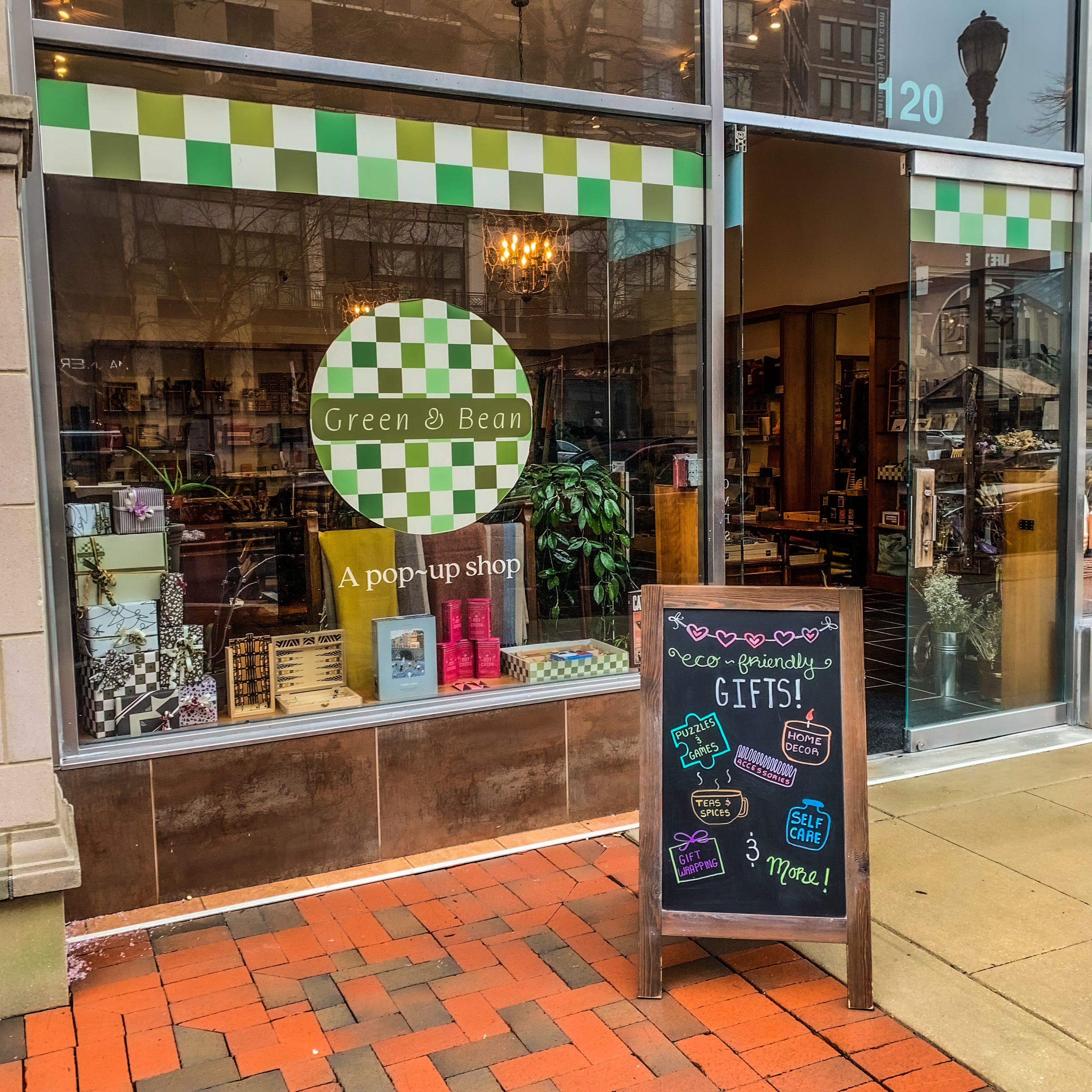 Front Window Display of Green & Bean Boutique at the Annapolis Town Center with a wooden sandwich board that says "eco friendly gifts!"