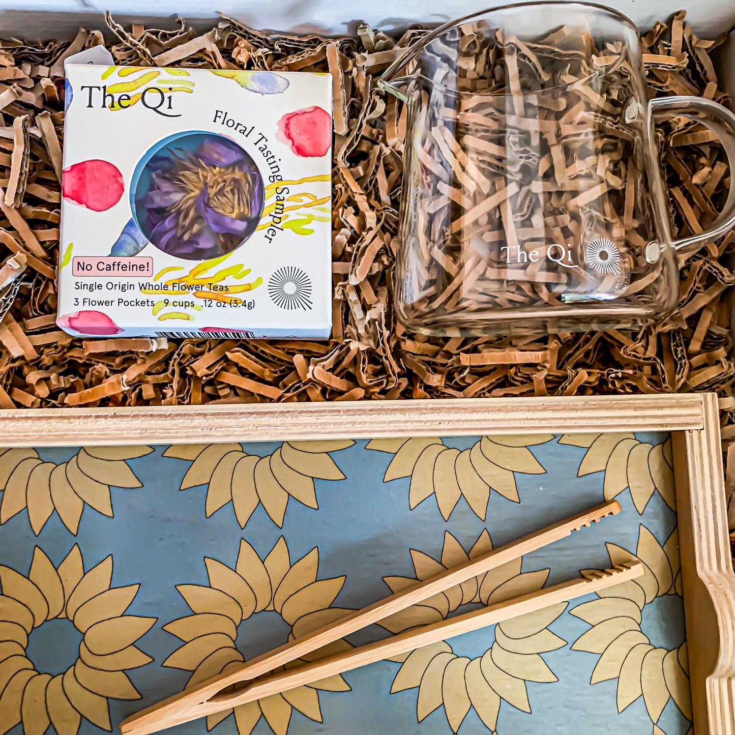 "Tea Time" Gift set close-up of flower tea sampler, wooden serving tray, bamboo tong and glass tea server