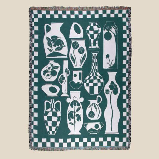 "Duffy" Blanket by Slowdown Studio shows a green and white checkered border on a green background with ceramic vases etched with flowers